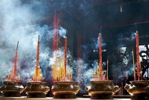 Smoking prayer sticks in copper urns. Thien Hau Pagoda, Ho Chi Minh, Vietnam.
